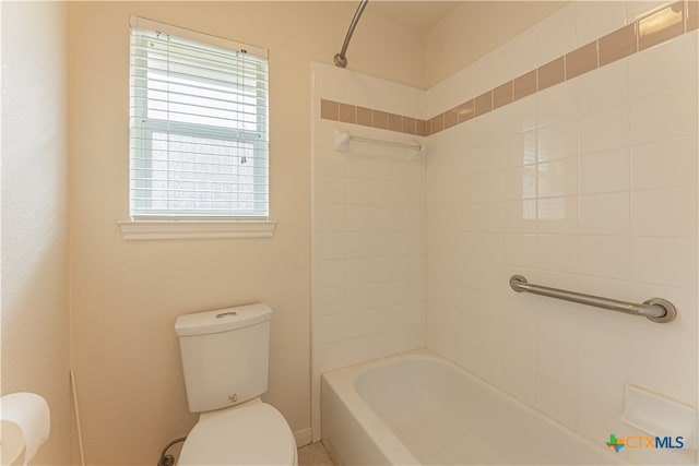 bathroom featuring tiled shower / bath and toilet