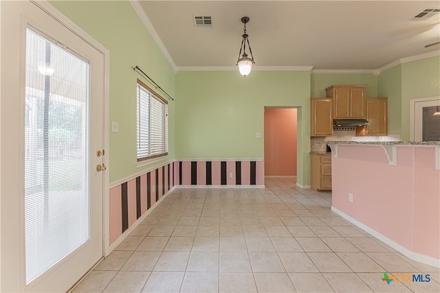 kitchen featuring light brown cabinets, a kitchen breakfast bar, hanging light fixtures, and exhaust hood