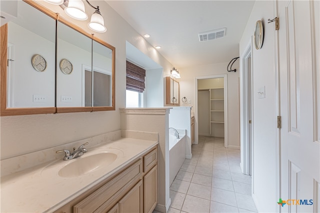 bathroom with vanity, a tub to relax in, and tile patterned floors