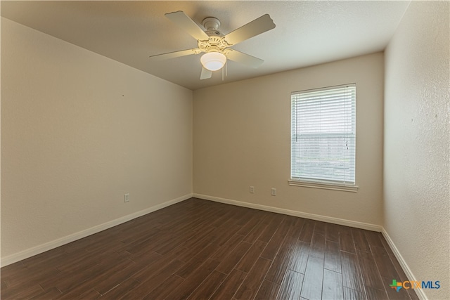 empty room featuring dark wood-type flooring and ceiling fan