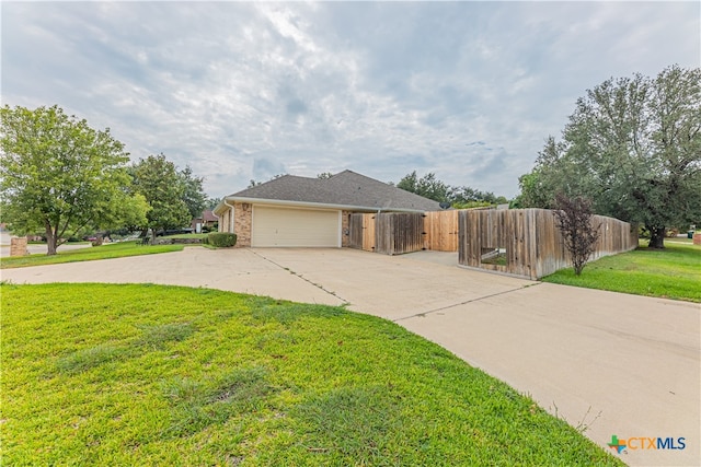 view of side of home featuring a garage and a yard