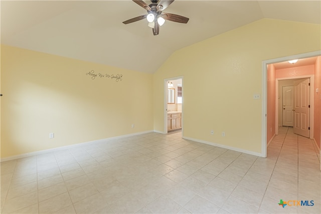 spare room with lofted ceiling, ceiling fan, and light tile patterned floors