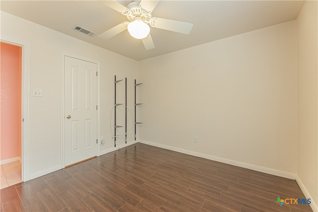 spare room featuring ceiling fan and dark hardwood / wood-style flooring