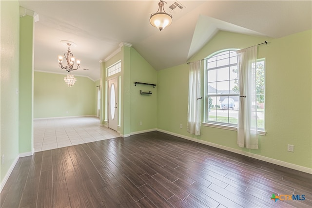 entryway with hardwood / wood-style floors, an inviting chandelier, vaulted ceiling, and ornamental molding