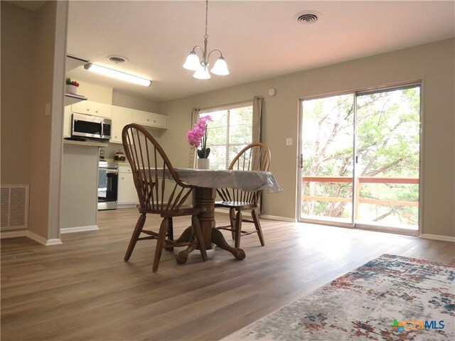 103 W Outer Dr, Canyon Lake, TX 78133 - dining space featuring a chandelier, light wood-style floors, and baseboards