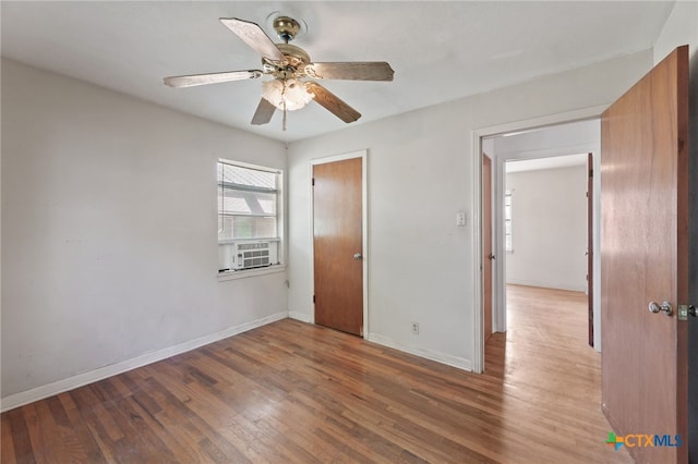 unfurnished bedroom featuring hardwood / wood-style flooring, ceiling fan, and cooling unit