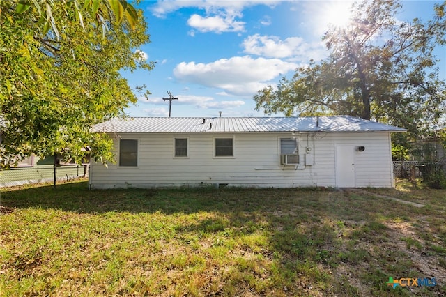 rear view of property with a lawn