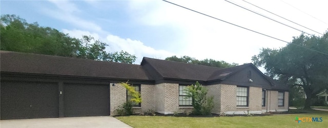 view of front of home with a garage, a front lawn, brick siding, and concrete driveway