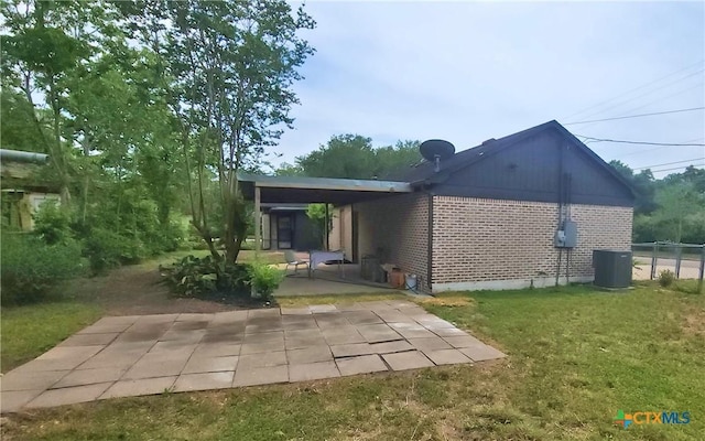 rear view of house with central air condition unit, a yard, and a patio