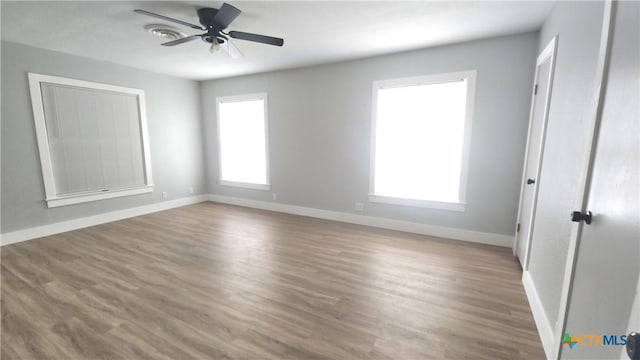 unfurnished bedroom featuring wood finished floors, baseboards, and ceiling fan