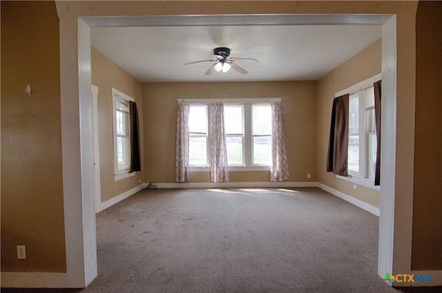 unfurnished room featuring ceiling fan, carpet flooring, and baseboards