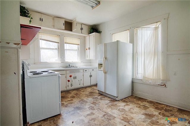 kitchen with white appliances, light countertops, and a sink