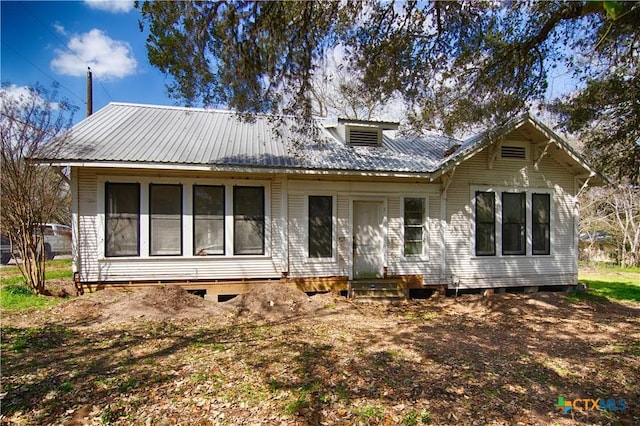 rear view of property featuring metal roof