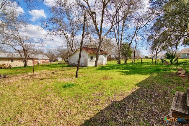 view of yard featuring fence and an outdoor structure