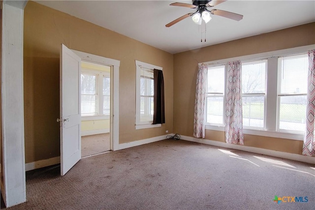 empty room with carpet, ceiling fan, and baseboards