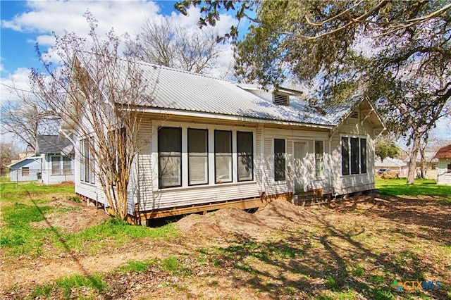 back of property with entry steps and metal roof