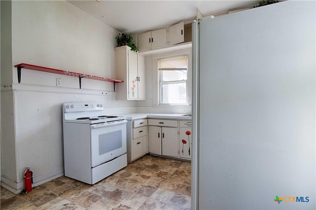 kitchen with white appliances, stone finish flooring, and light countertops