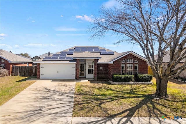 view of front facade featuring a garage, concrete driveway, fence, a front lawn, and brick siding