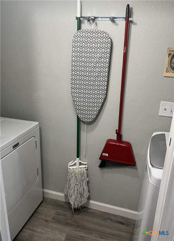 clothes washing area with laundry area, baseboards, wood finished floors, and washer / dryer