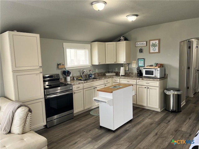 kitchen featuring lofted ceiling, white microwave, dark wood-type flooring, stainless steel range with electric cooktop, and a sink