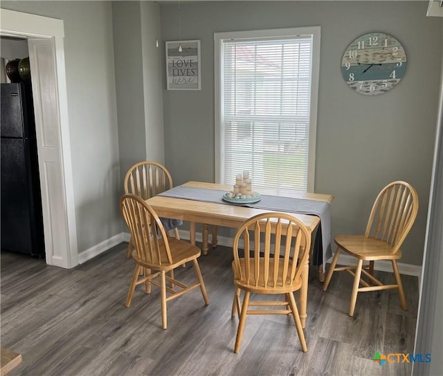 dining space with baseboards and wood finished floors