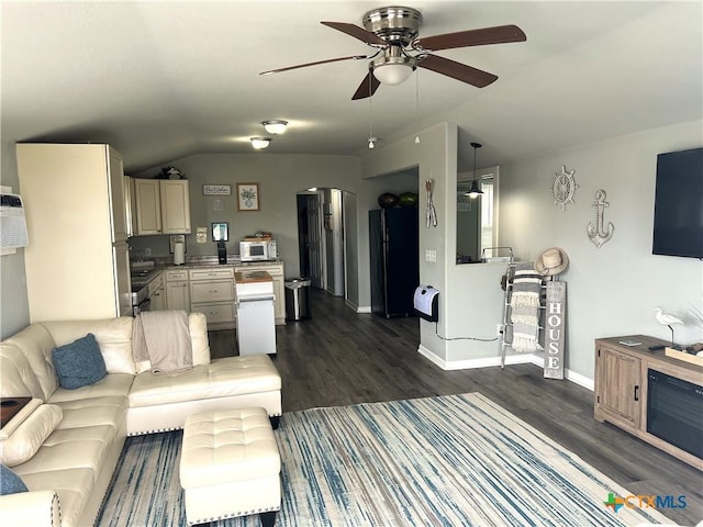 living room featuring vaulted ceiling, ceiling fan, dark wood-type flooring, and baseboards