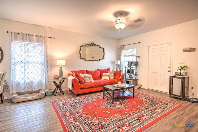 living area with wood finished floors and ceiling fan