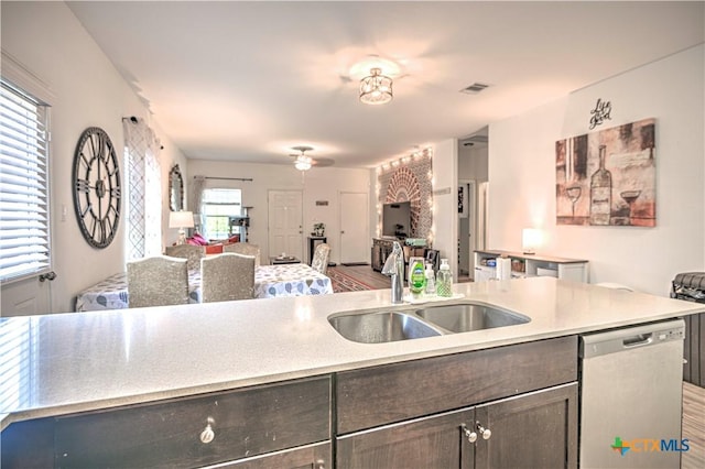 kitchen with dishwasher, open floor plan, a sink, and light countertops