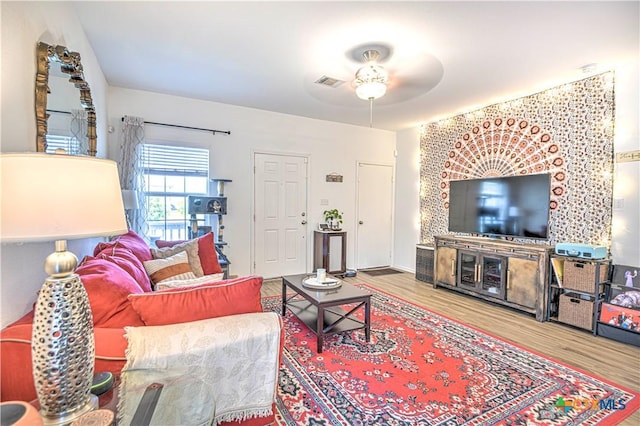 living area featuring a ceiling fan and wood finished floors