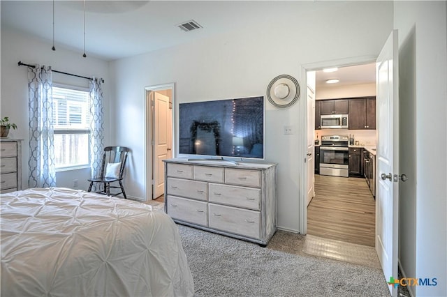 bedroom featuring light carpet and baseboards