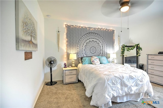 carpeted bedroom featuring baseboards and a ceiling fan