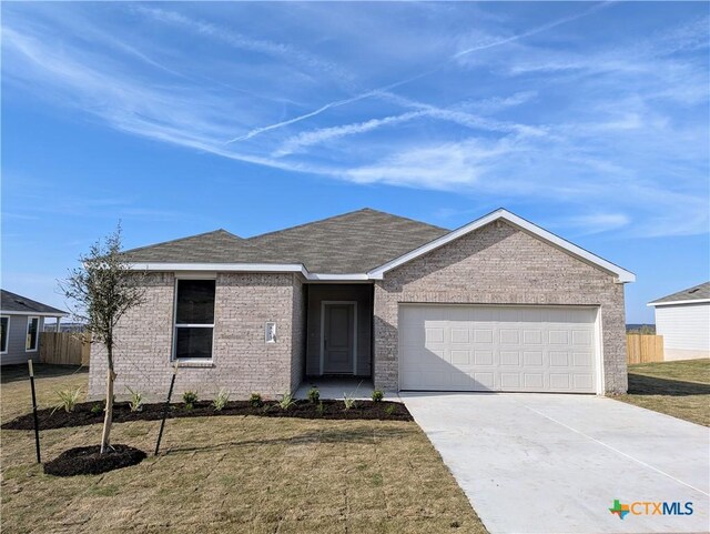 ranch-style home featuring a garage and a front lawn