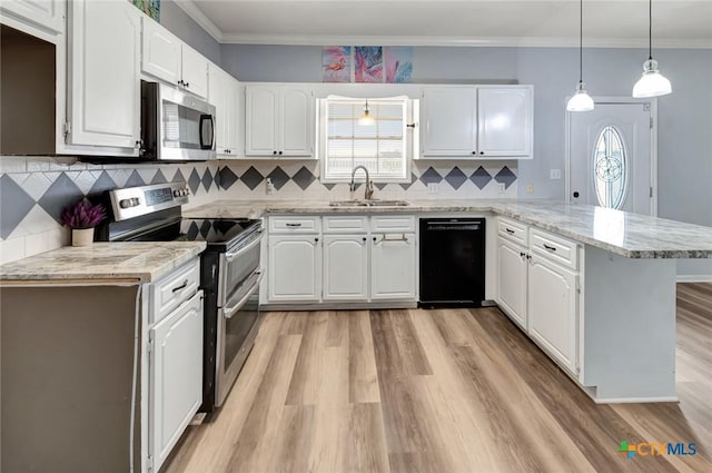 kitchen featuring a peninsula, a sink, white cabinets, hanging light fixtures, and appliances with stainless steel finishes