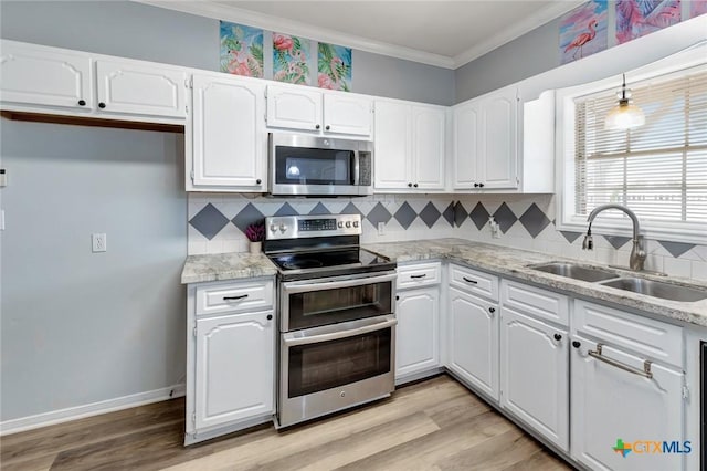 kitchen featuring pendant lighting, a sink, white cabinetry, appliances with stainless steel finishes, and crown molding