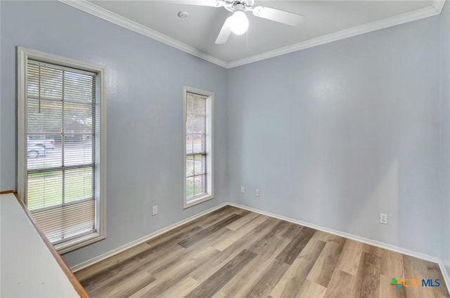 empty room with a ceiling fan, a wealth of natural light, crown molding, and light wood-style flooring