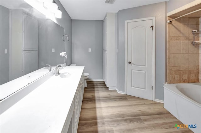 full bathroom with shower / bathtub combination, toilet, vanity, wood finished floors, and baseboards