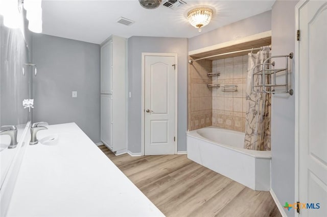 full bath featuring baseboards, visible vents, wood finished floors, and shower / tub combo with curtain