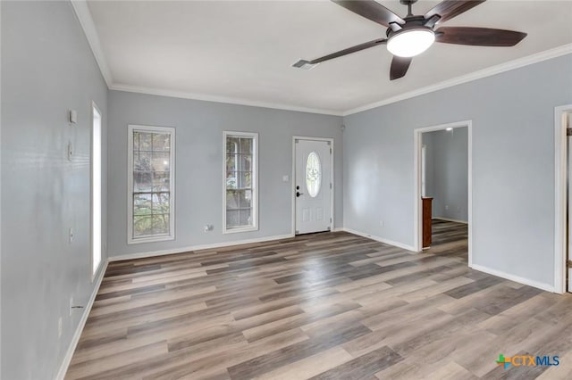 foyer with ceiling fan, visible vents, baseboards, light wood-type flooring, and crown molding