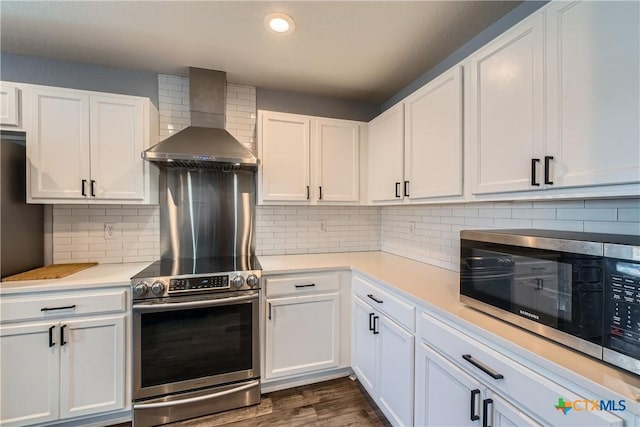 10122 Divine Breeze, San Antonio, TX 78251 - kitchen featuring wall chimney range hood, stainless steel appliances, light countertops, white cabinets, and recessed lighting