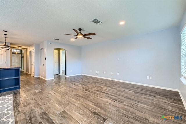 10122 Divine Breeze, San Antonio, TX 78251 - unfurnished living room with ceiling fan, arched walkways, dark wood-style flooring, and a textured ceiling
