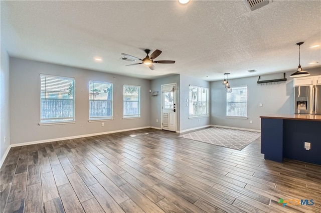 10122 Divine Breeze, San Antonio, TX 78251 - unfurnished living room with a ceiling fan, plenty of natural light, a textured ceiling, dark wood-style flooring, and recessed lighting
