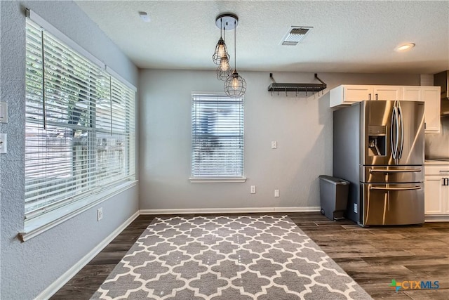 10122 Divine Breeze, San Antonio, TX 78251 - unfurnished dining area with dark wood finished floors and a textured ceiling