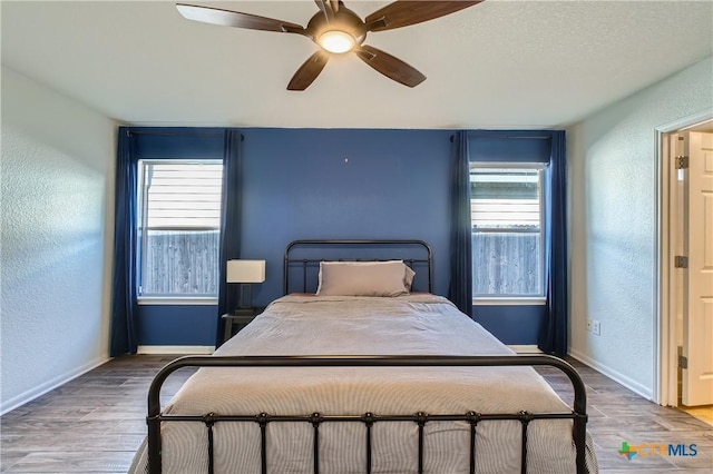 10122 Divine Breeze, San Antonio, TX 78251 - bedroom with a textured wall, wood finished floors, and ceiling fan