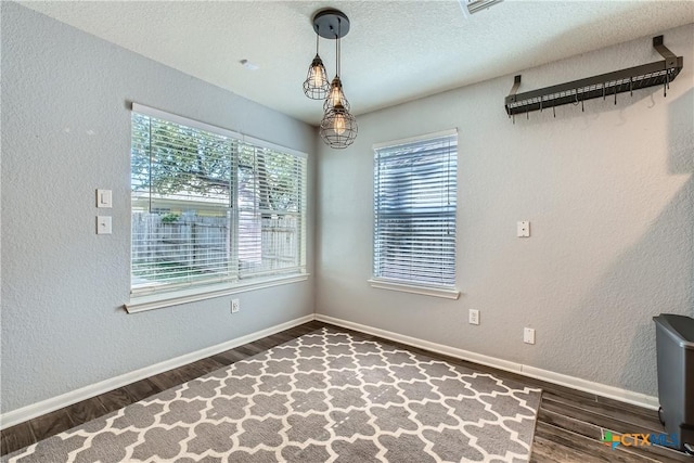 10122 Divine Breeze, San Antonio, TX 78251 - unfurnished dining area featuring wood finished floors, a textured wall, and a textured ceiling