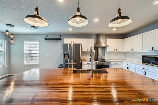 10122 Divine Breeze, San Antonio, TX 78251 - kitchen featuring stainless steel appliances, wall chimney range hood, backsplash, pendant lighting, and white cabinets