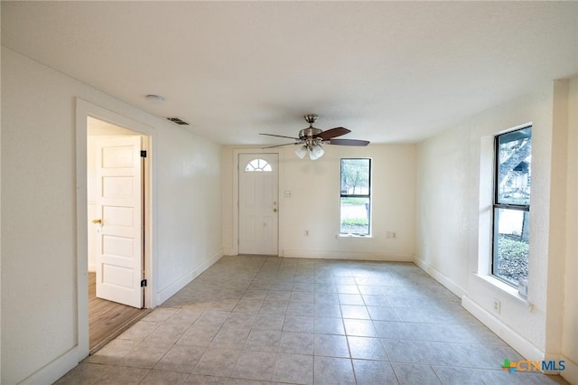 tiled spare room with ceiling fan