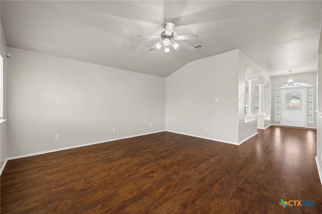 spare room with dark wood finished floors, visible vents, vaulted ceiling, baseboards, and ceiling fan with notable chandelier