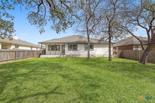 back of property featuring a fenced backyard and a lawn