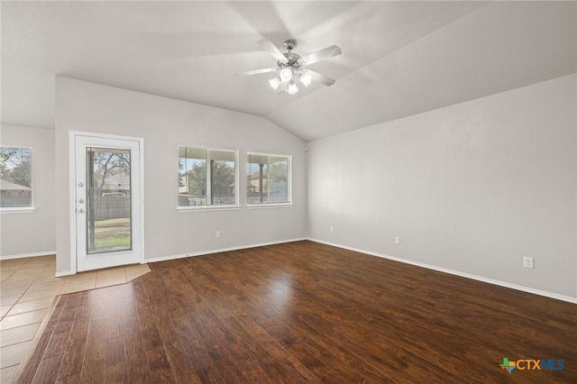 empty room with lofted ceiling, a healthy amount of sunlight, and wood finished floors