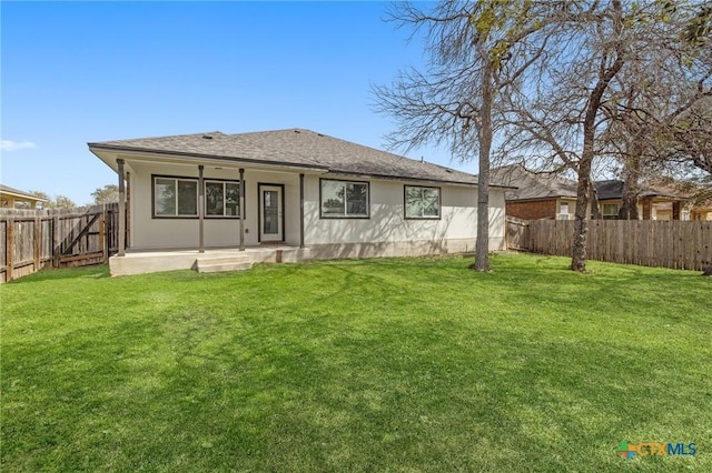 back of house featuring a fenced backyard, a lawn, and a patio